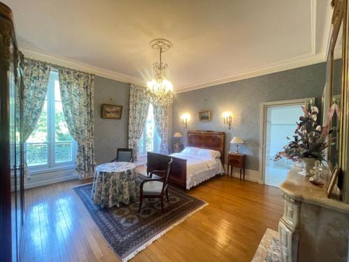 a bedroom with a bed and a table at LES PAYRATONS in Saint-Gérand-le-Puy