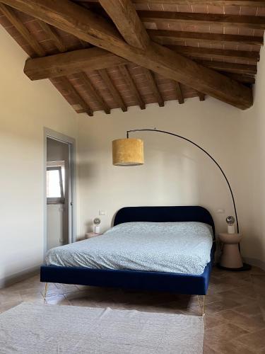 a bedroom with a blue bed with a ceiling at The Loft By Birillo in Poggibonsi