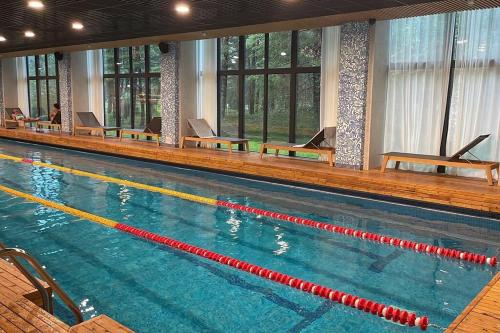 a large swimming pool with chairs in a building at Suite am Meer / Seaside suite in Ķesterciems