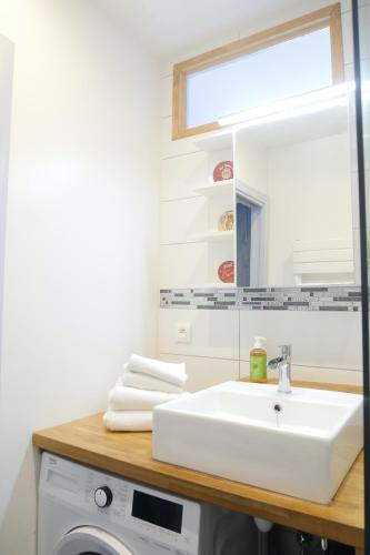 une salle de bain avec un lavabo et un miroir dans l'établissement SURPRENANTES - La Biscuiterie, à Nantes