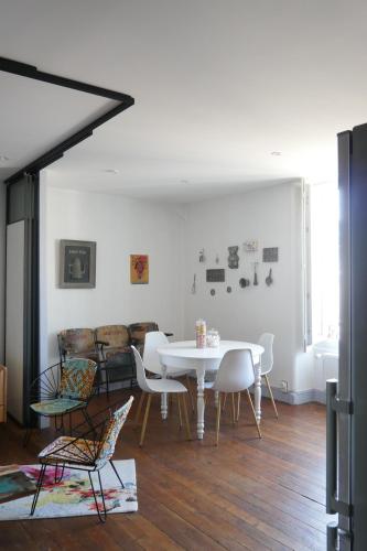 une salle à manger avec une table et des chaises blanches dans l'établissement SURPRENANTES - La Biscuiterie, à Nantes