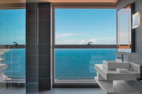 a bathroom with a view of the ocean through a window at Four Points by Sheraton Oran in Oran