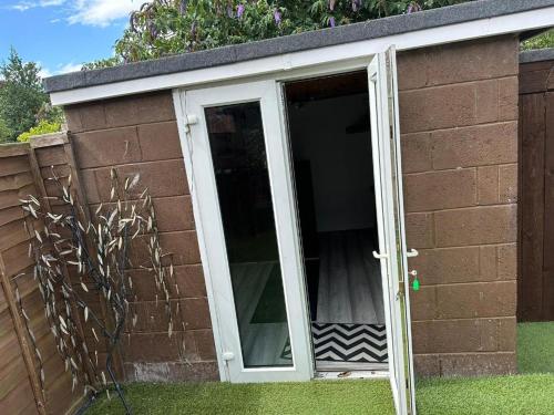 a small shed with a door in the grass at A Summer Stay in Middlesbrough