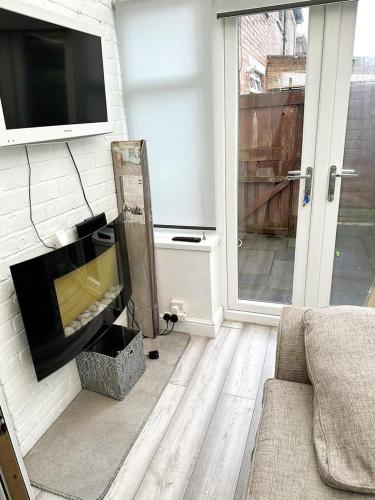 a living room with a couch and a tv on a wall at A Summer Stay in Middlesbrough