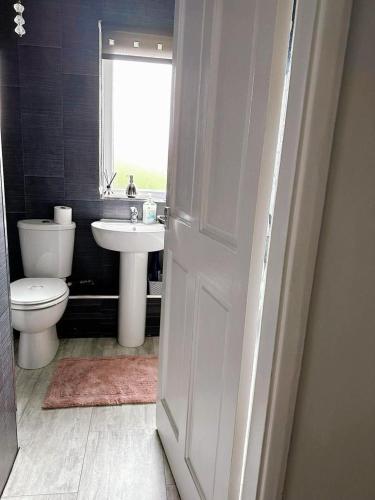 a bathroom with a toilet and a sink and a window at A Summer Stay in Middlesbrough