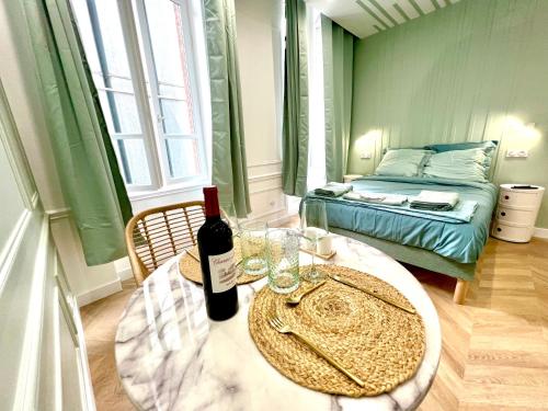 Cette chambre comprend une table avec une bouteille de vin et un lit. dans l'établissement Hyper centre Toulouse Capitole, à Toulouse