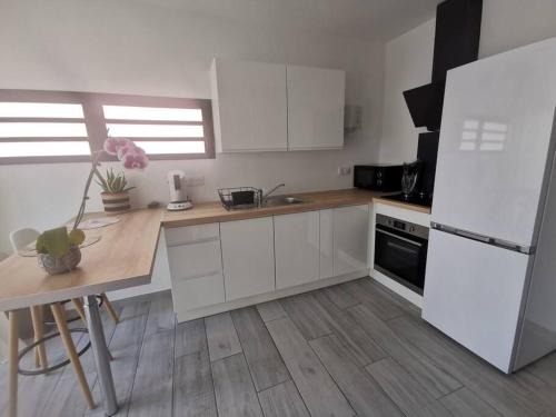 a kitchen with white cabinets and a white refrigerator at La Caz'A Loca in Saint-Pierre
