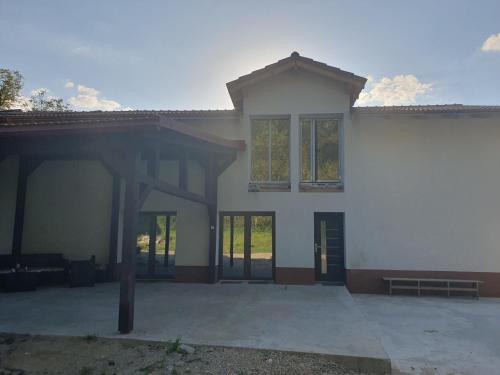 un gran edificio blanco con puertas y ventanas de cristal en Vila AliBi Valiug - 200m from Ponton Casa Baraj en Văliug