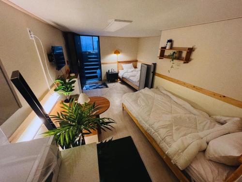 a room with two beds and a couch in it at Jnineguesthouse in Seoul
