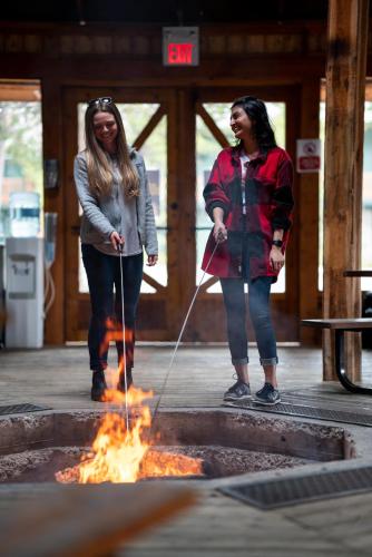 two women are standing around a fire at Lake Louise Inn in Lake Louise