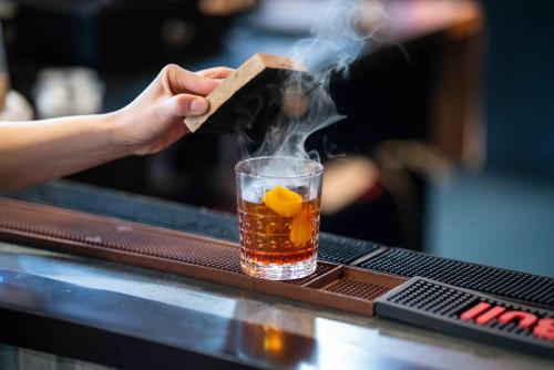 a person is holding a cigarrette in a drink at Lake Louise Inn in Lake Louise
