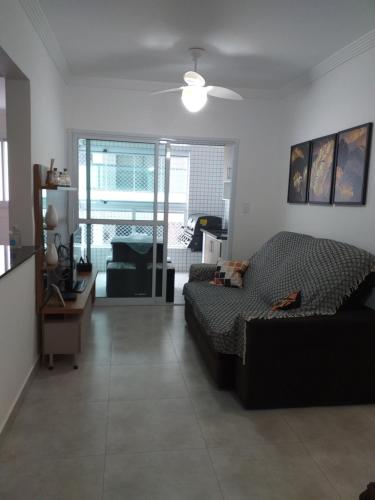 sala de estar con cama y sofá en Apartamento Vista Mar Mongaguá en Mongaguá