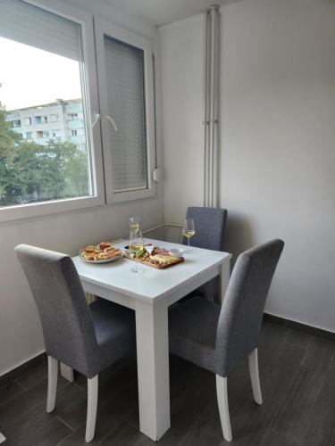 een witte tafel met stoelen en een bord met eten erop bij Stan na dan Nova Varoš in Banja Luka