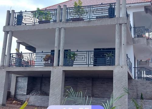 a building with a balcony with potted plants on it at Beautiful 2-Bed Apartment in Akright City Bwebajja in Namulanda