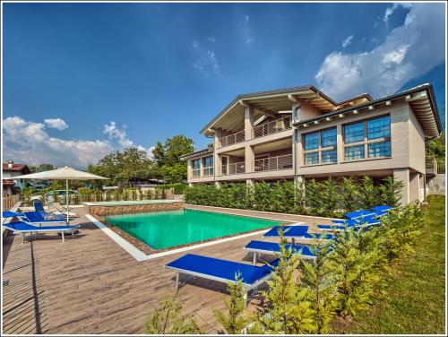 a house with a swimming pool and blue lounge chairs at Villa TaDi LaRo Luxury Panorama Comer See Colico in Carriola