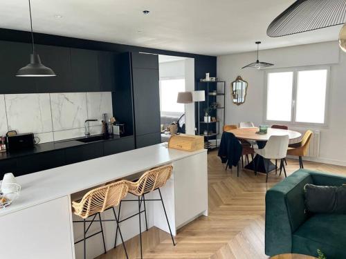 a kitchen and living room with a table and chairs at Appartement lumineux 6/pers in Lanester