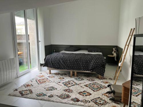 1 dormitorio con cama y alfombra en Appartement lumineux quatre personnes en Lanester