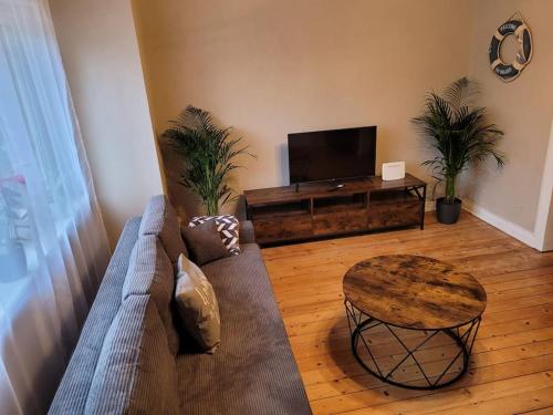 a living room with a couch and a table and a tv at Willi's Moselschlösschen in Neumagen-Dhron