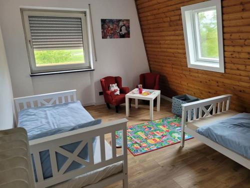 Zimmer mit 2 Betten, einem Tisch und einem Stuhl in der Unterkunft Willi's Moselschlösschen in Neumagen-Dhron