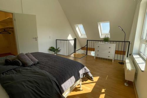 um quarto com uma cama grande num quarto com janelas em Shine Apartment Wackersdorf II em Wackersdorf