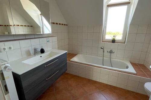 a white bathroom with a tub and a sink at Shine Apartment Wackersdorf II in Wackersdorf