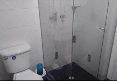 a bathroom with a shower with a toilet and a glass door at Habitación con baño privado cerca al aeropuerto in Bogotá