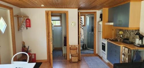 uma cozinha com armários azuis e um tecto de madeira em Njut av solen, havet, stranden! em Sölvesborg
