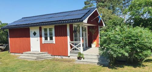 una casita roja con paneles solares. en Njut av solen, havet, stranden! en Sölvesborg