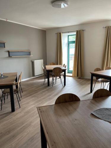 a dining room with tables and chairs and a window at Neu renoviert: 11 Zimmer mit großer Wohnküche, mitten in der Natur in Neu Gaarz