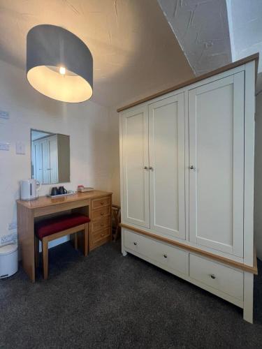 a bathroom with a sink and a desk and a mirror at The Ship and Pilot Inn in Ilfracombe