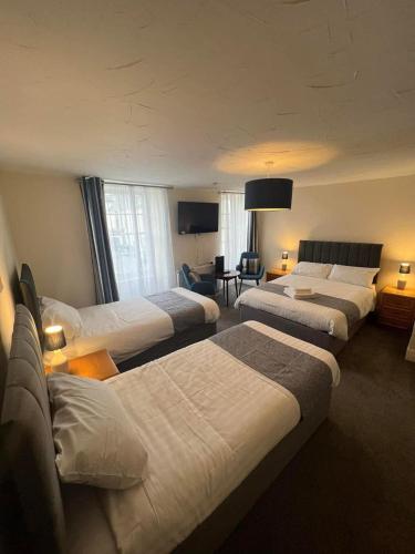 a hotel room with four beds and a couch at The Ship and Pilot Inn in Ilfracombe