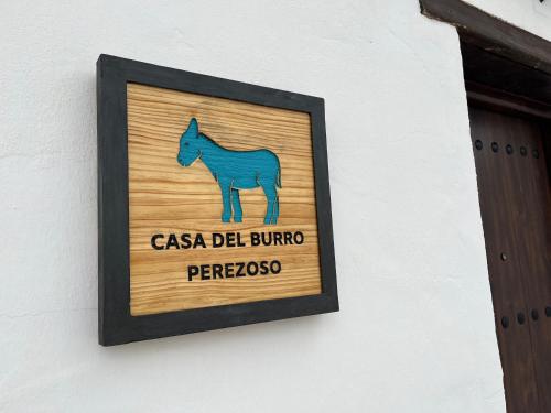 un cartel en una pared con un caballo. en Casa del Burro Perezoso, en Almáchar