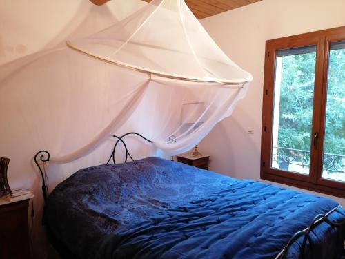 1 dormitorio con 1 cama con mosquitera. en Maison au calme entre vignes et Luberon, en Saint-Martin-de-la-Brasque