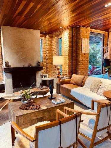 a living room with a couch and a fireplace at Casa da Pedra Serrinha in Resende