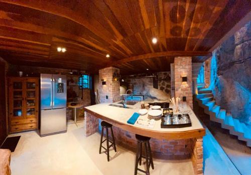 a kitchen with a large island in the middle of a room at Casa da Pedra Serrinha in Resende