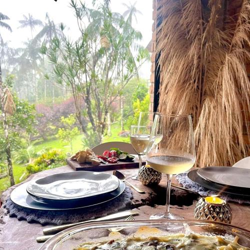 a table with plates of food and a glass of wine at Casa da Pedra Serrinha in Resende