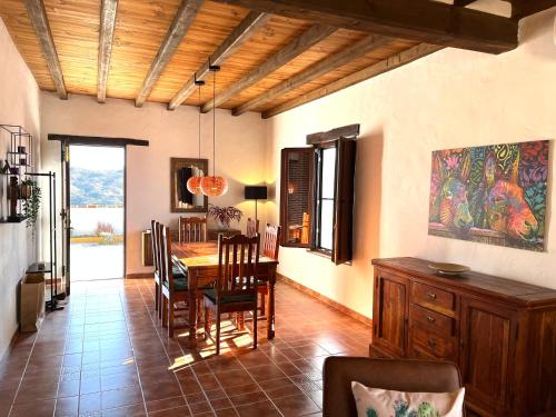 - une salle à manger avec une table et des chaises en bois dans l'établissement Casa del Burro Perezoso, à Almáchar