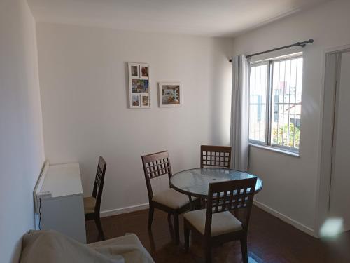 comedor con mesa, sillas y ventana en Apartamento Completo, Diária ou Temporada, en Salvador