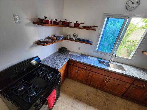 a kitchen with a stove and a sink and a window at Bella Villa Roomy apartment at 5 min walk to the beach in Las Galeras