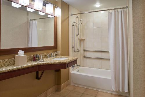 uma casa de banho com uma banheira, um lavatório e um chuveiro em Chicago Marriott Midway em Bedford Park
