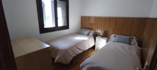a small room with two beds and a window at L'Artiga in Sesué