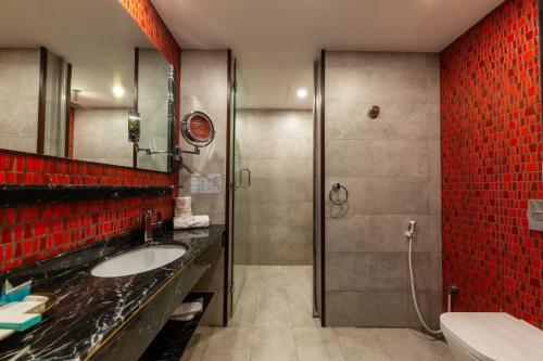 a bathroom with a sink and a shower with red tiles at فندق روزالينا in Yanbu