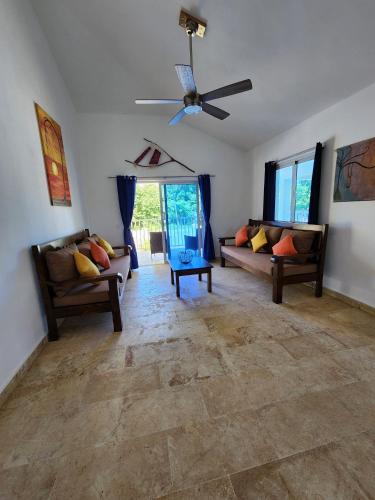 a living room with two couches and a ceiling fan at Bella Villa Roomy apartment at 5 min walk to the beach in Las Galeras