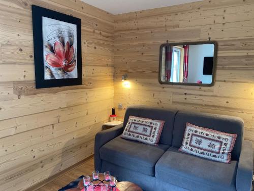 a living room with a couch and a mirror at Serre Chevalier Studio l'ETAP' au pied des pistes in La Salle-les-Alpes