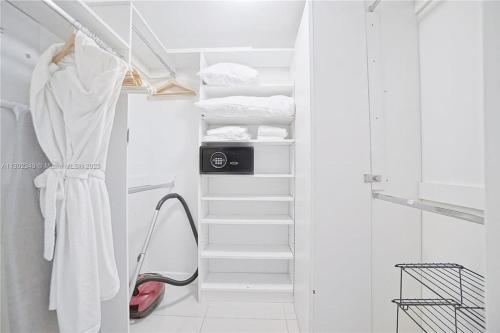 Armario blanco con toallas blancas y espejo en Icon Luxury 34th Floor Amazing Oceanview, Brickell, en Miami
