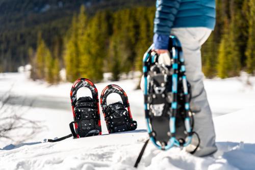 a person holding a pair of skis in the snow at Lake Louise Inn in Lake Louise