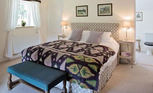una camera con un grande letto con una panca blu di The Coach House, Wrexham Road a Wrexham