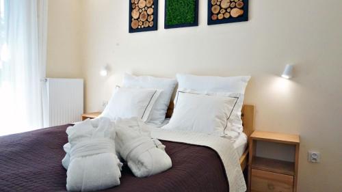 - une chambre avec un lit doté de draps et d'oreillers blancs dans l'établissement Green Port Apartament Mango, à Kołobrzeg