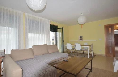 ein Wohnzimmer mit einem Sofa und einem Tisch in der Unterkunft Casa Mar de Ardora in Carnota