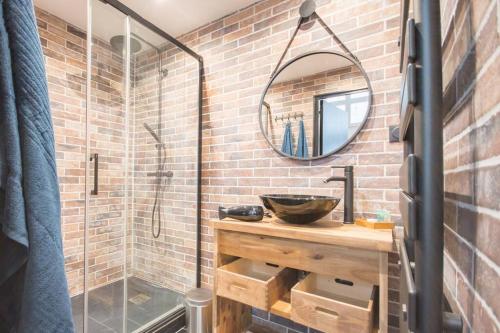 ein Bad mit einem Waschbecken und einer Dusche mit einem Spiegel in der Unterkunft L'appar-T, esprit industriel à 2 pas de l'eau ! in Le Havre
